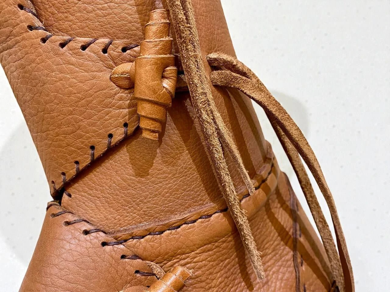 Handmade medieval leather boot with full-grain texture, wrap laces, and detailed stitching for LARP or SCA reenactment.